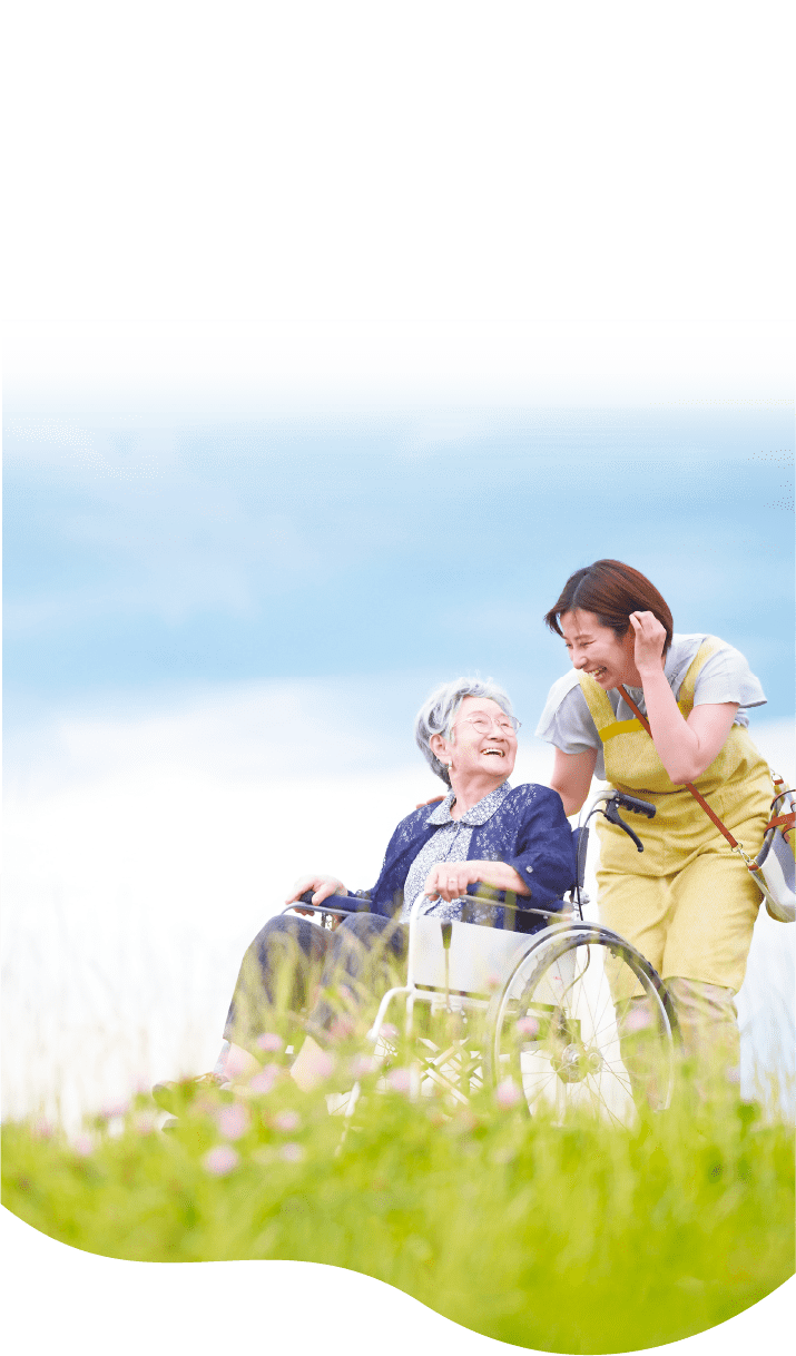 女性が車椅子に乗っている高齢の女性に笑顔で話しかけている様子